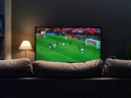 Is enforcement enough to stop £700m sports piracy losses? Football match on widescreen flat TV at home, sport and entertainment concept