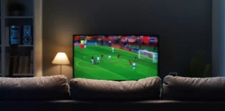 Is enforcement enough to stop £700m sports piracy losses? Football match on widescreen flat TV at home, sport and entertainment concept