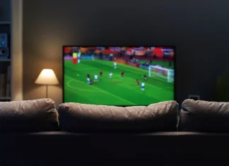 Is enforcement enough to stop £700m sports piracy losses? Football match on widescreen flat TV at home, sport and entertainment concept