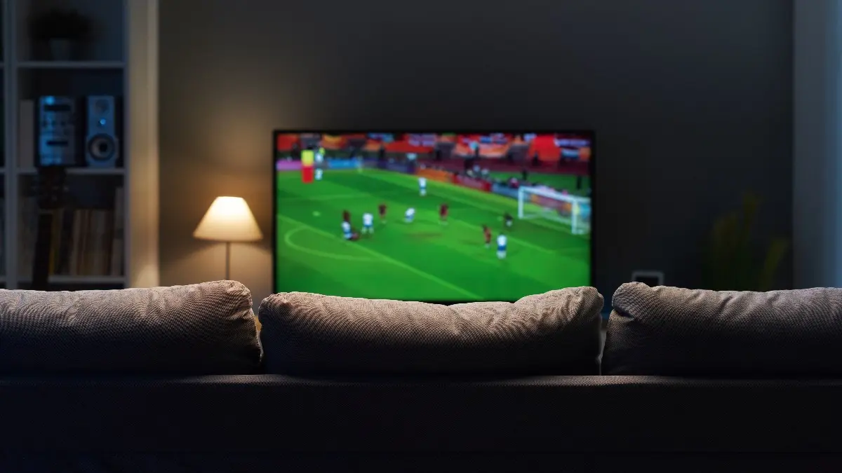 Football match on widescreen flat TV at home, sport and entertainment concept