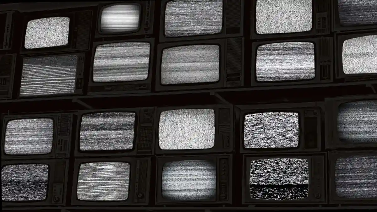 Wall of old wooden black and white TV screens, static noise caused by bad signal reception blackout